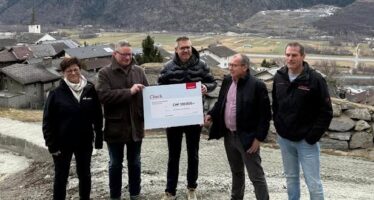 100’000 Franken gegen Steinschlag: Vertreter der Mobiliar Versicherung übergeben Stefan Troger, Gemeindepräsident von Raron-St. German, einen Check.